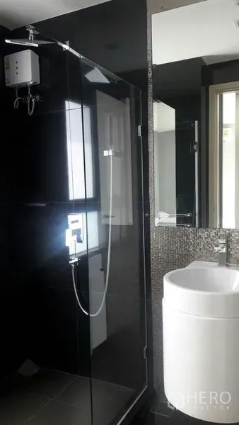 Condominium for rent in Khlong Toei, Bangkok - Modern bathroom with glass shower enclosure, mosaic wall, and water heater
