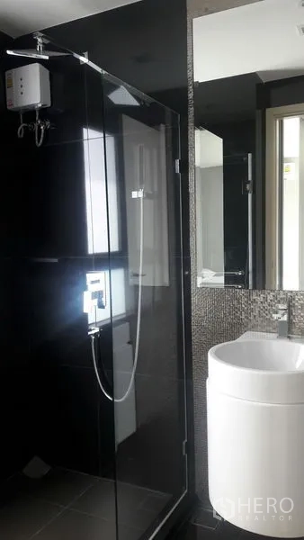 Condominium for rent in Khlong Toei, Bangkok - Modern bathroom with glass shower enclosure, mosaic wall, and water heater