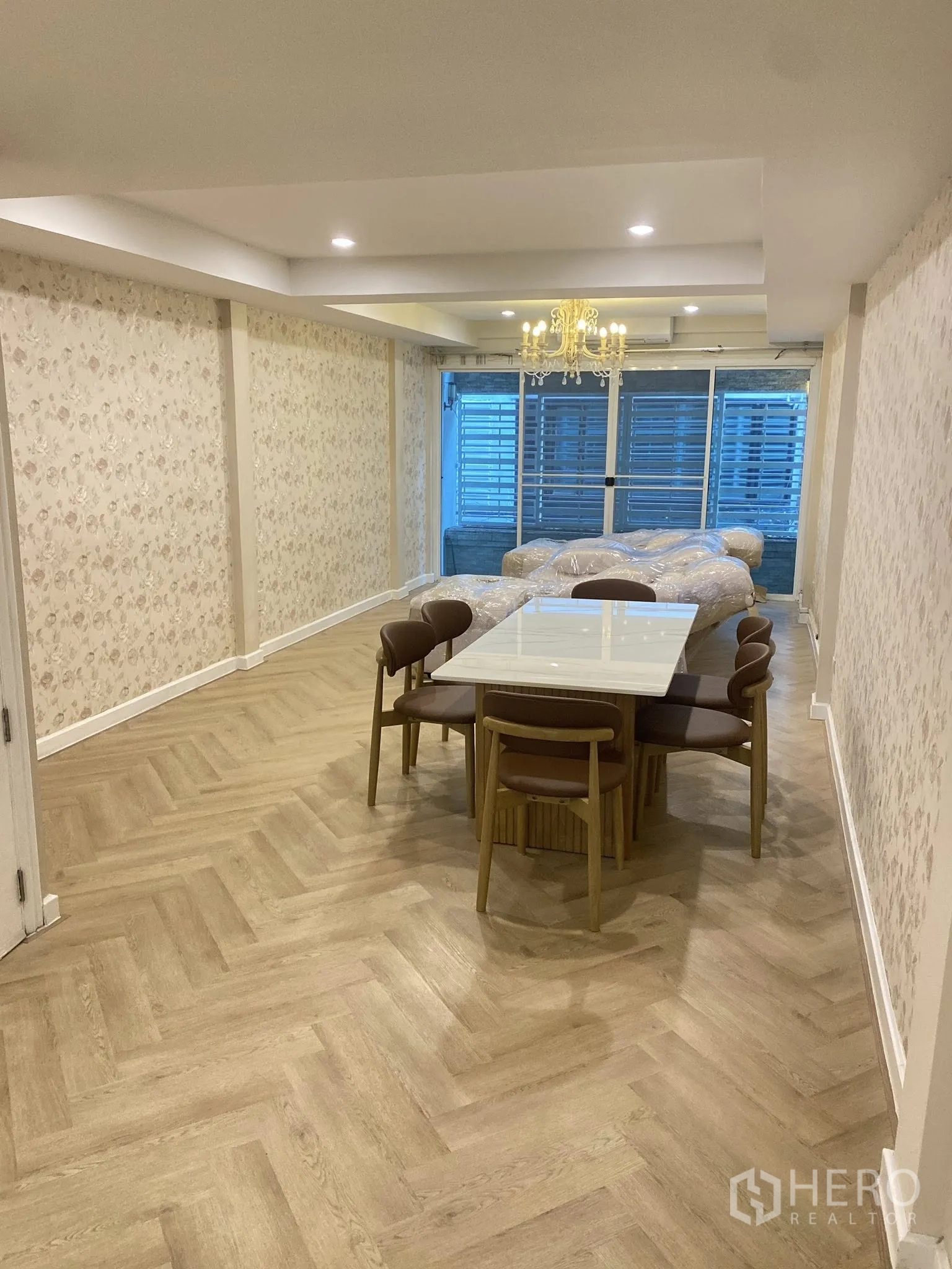 Home Office for rent in Pathum Wan, Bangkok - Dining zone with marble‑top table, chandelier, and sliding screened frontage.