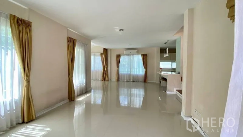 Detached House for rent in Bang Kapi, Bangkok - Open-plan living and dining space with glossy tile floor and wide windows.