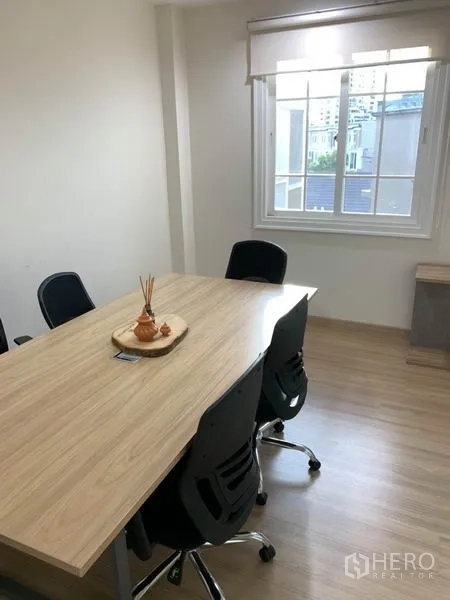 带办公室的家 出租或出售在Bang Na, Bangkok - 小型会议室，木质会议桌、办公椅与窗户。