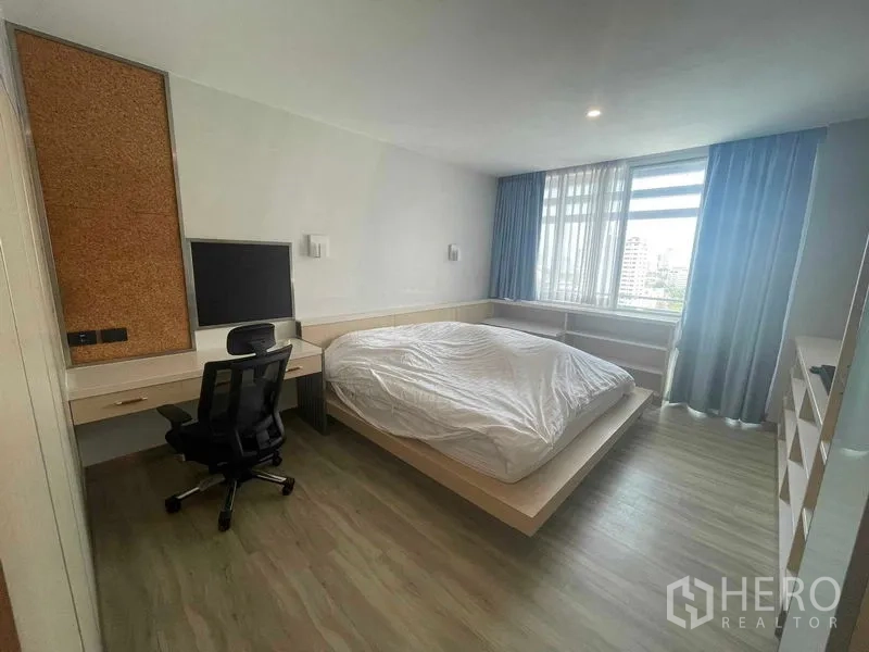 Condominium for rent in Sathon, Bangkok - Spacious bedroom with platform bed, work desk, large window and city outlook at Natural Place Suite.