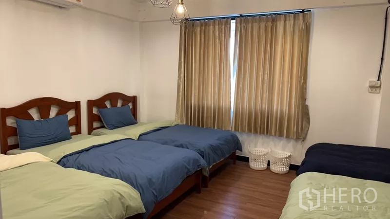 带办公室的家 出租或出售在Phra Khanong, Bangkok - 卧室内三张单人床，素色窗帘与吊灯。