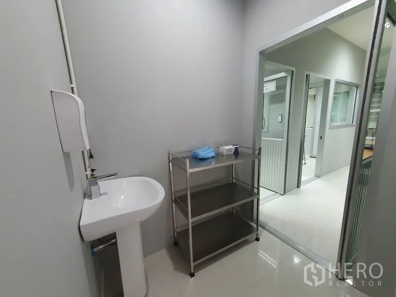 Factory for sale in Lam Luk Ka, Pathum Thani - Hygiene area with hand basin, stainless steel shelving and view into a controlled corridor.