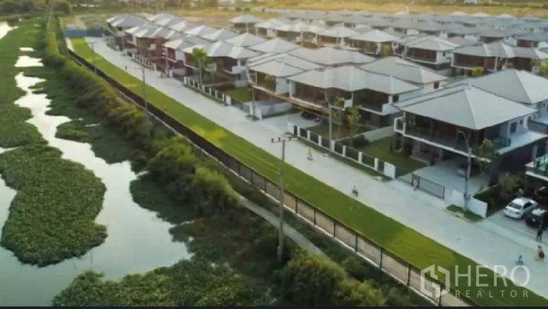 บ้าน ให้เช่าหรือขายในBang Sao Thong, Samut Prakan - ภาพมุมสูงหมู่บ้านติดคลอง ถนนกว้างและบ้านเรียงตัวเป็นระเบียบ