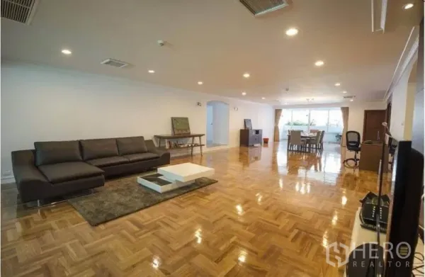 อพาร์ทเมนท์ ให้เช่าในRatchathewi, Bangkok - ห้องนั่งเล่นกว้างพื้นปาร์เกต์ ไฟดาวน์ไลท์ โซฟาหนัง ในอพาร์ตเมนต์ย่านอโศกใกล้บีทีเอส