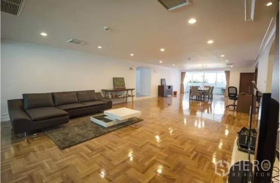 อพาร์ทเมนท์ ให้เช่าในRatchathewi, Bangkok - ห้องนั่งเล่นกว้างพื้นปาร์เกต์ ไฟดาวน์ไลท์ โซฟาหนัง ในอพาร์ตเมนต์ย่านอโศกใกล้บีทีเอส