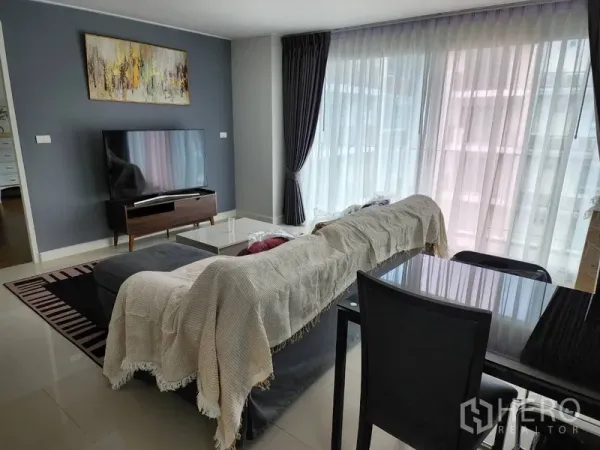 公寓 出租在Watthana, Bangkok - 客厅配电视柜、薄纱窗帘、深色主墙与四人餐桌。