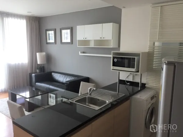 คอนโด ให้เช่าหรือขายในWatthana, Bangkok - ครัวขนาดกะทัดรัด เคาน์เตอร์หินแกรนิต อ่างล้างจาน ไมโครเวฟ และเครื่องซักผ้า ติดกับพื้นที่นั่งเล่น