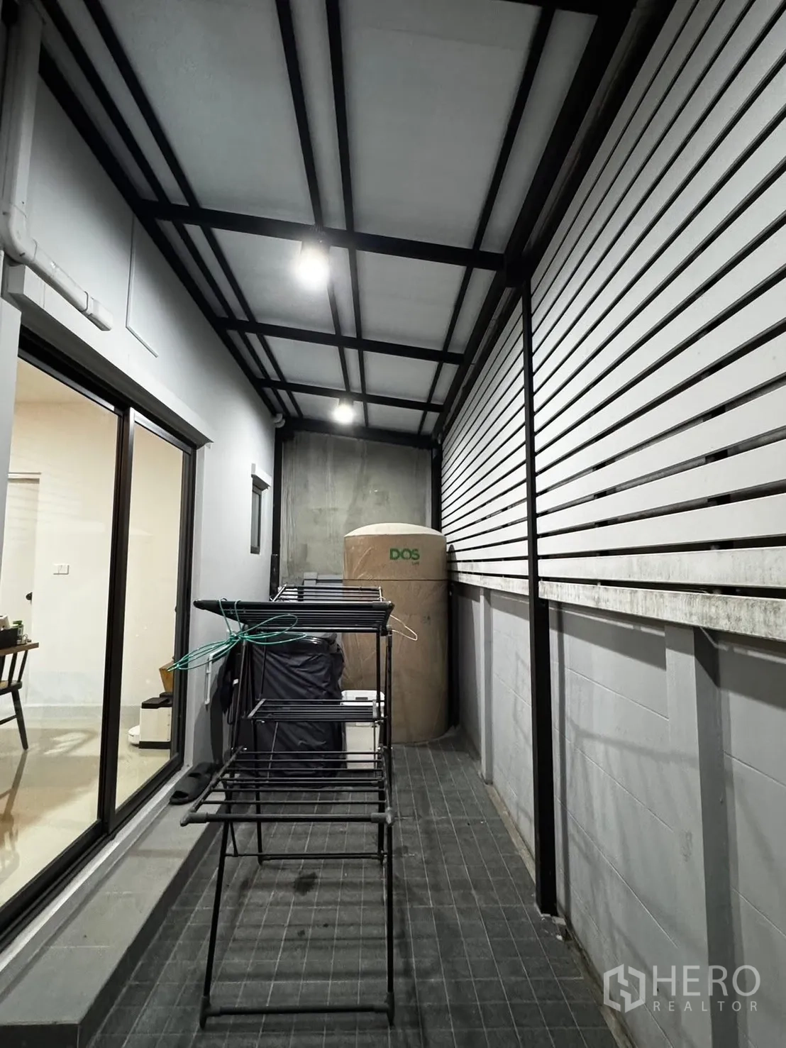 Townhouse for rent in Bang Phli, Samut Prakan - Covered side patio and laundry area with tiled floor and sliding glass door.