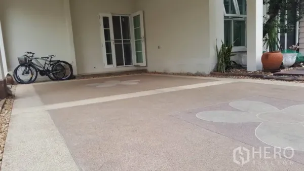 独立式住宅 出售在Mueang Nonthaburi, Nonthaburi - 带顶车库，花纹混凝土地面，靠墙放置自行车，旁边是玻璃法式门