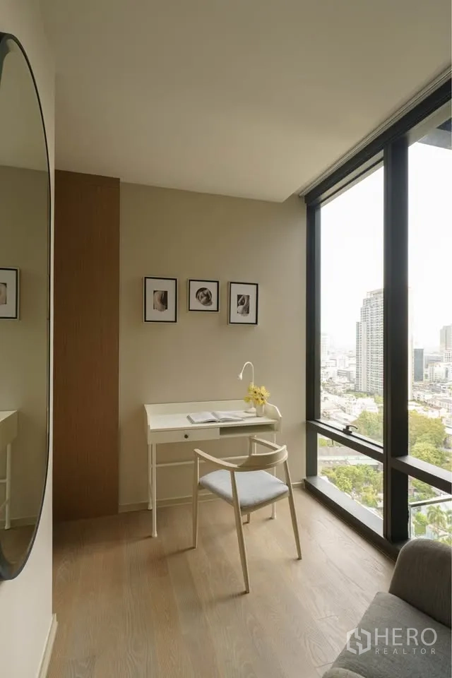 Condominium for rent in Bang Rak, Bangkok - Study corner with white desk by floor-to-ceiling windows overlooking the city.