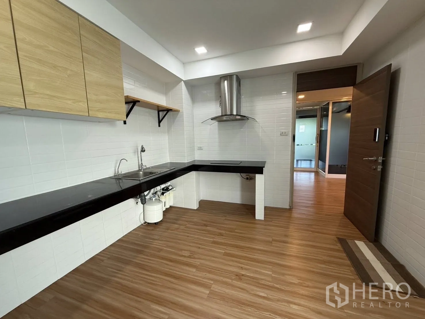 Home Office for rent or sale in Yan Nawa, Bangkok - Fitted kitchen with white tiled walls, black countertops, sink, and range hood.