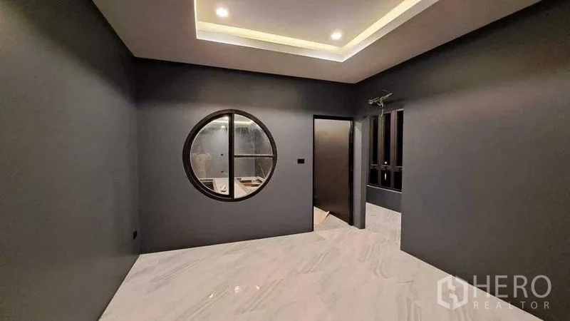 บ้าน ขายในChachoengsao - ห้องทันสมัยมีช่องหน้าต่างกลมเด่น ไฟซ่อนเพดาน ผนังสีเทาและพื้นลายหินอ่อนเงา