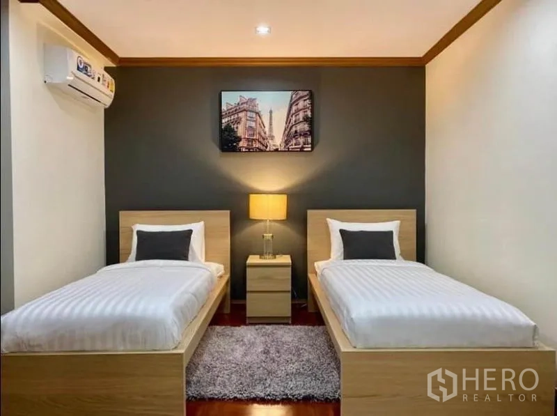 คอนโด ให้เช่าในKhlong Toei, Bangkok - ห้องนอนรองเตียงเดี่ยว 2 เตียง มีโต๊ะหัวเตียงและผนังเน้นสีเข้ม