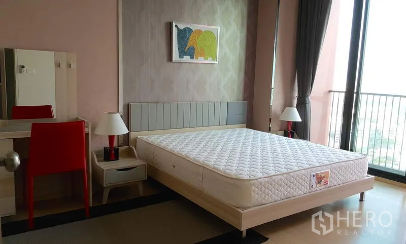 คอนโด ให้เช่าในPhaya Thai, Bangkok - ห้องนอนใหญ่สว่าง เตียงขนาดใหญ่ โต๊ะเครื่องแป้ง โคมไฟข้างเตียง และประตูกระจกออกระเบียง