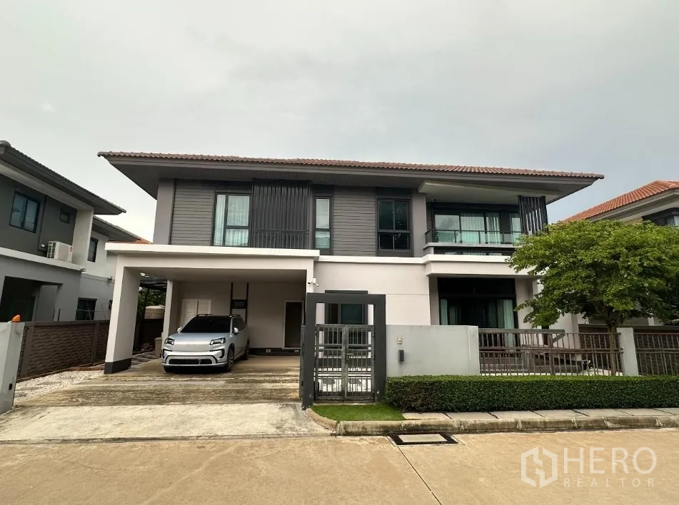 บ้าน ให้เช่าในLam Luk Ka, Pathum Thani - บ้านสองชั้นสไตล์โมเดิร์น มีที่จอดรถในร่ม ประตูรั้ว และสวนหน้าบ้าน