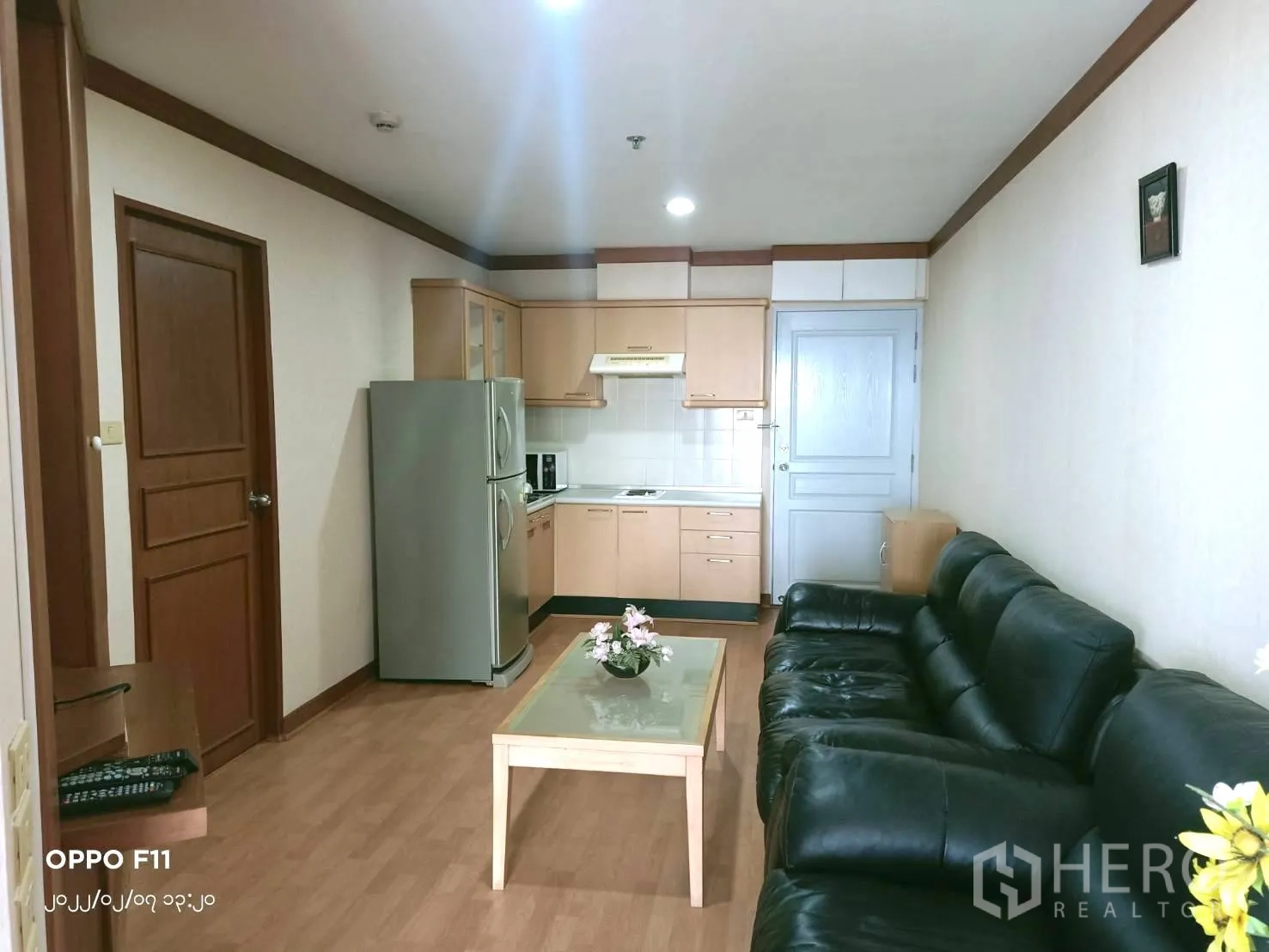 คอนโด ให้เช่าในKhlong Toei, Bangkok - พื้นที่นั่งเล่นและครัวแบบเปิดพร้อมตู้เย็นขนาดใหญ่ โซฟาหนัง และตู้ลายไม้