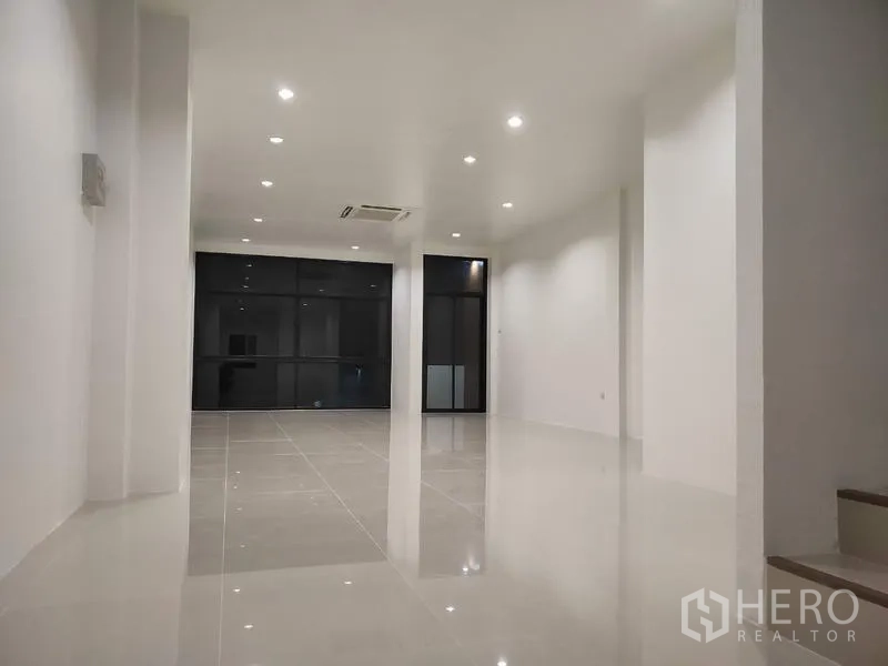 Home Office for sale in Lam Luk Ka, Pathum Thani - Bright open workspace with downlights, glossy tiles and black-framed glass partitions.