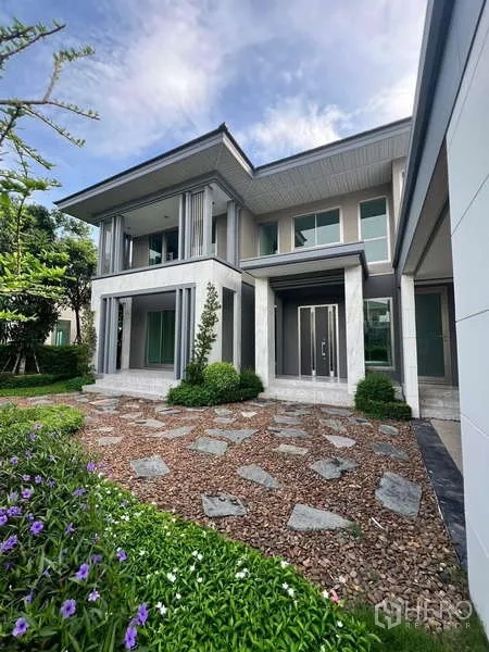 บ้าน ให้เช่าหรือขายในLat Krabang, Bangkok - ภายนอกบ้านสองชั้น ทางเดินหิน และสวนจัดแต่ง