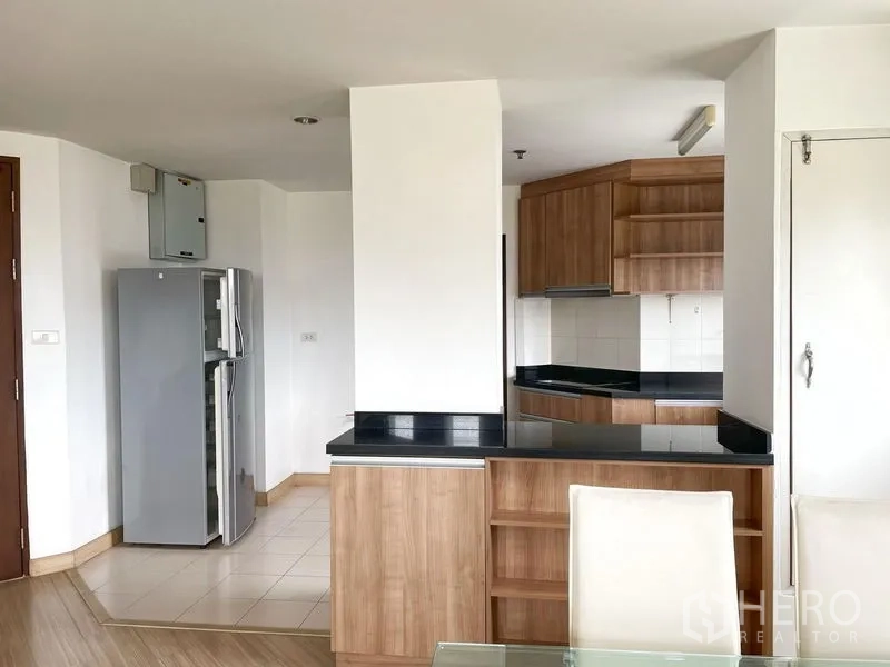 คอนโด ให้เช่าในKhlong Toei, Bangkok - ทางเข้าครัวพร้อมเคาน์เตอร์บาร์ ตู้ไม้ ท็อปหินสีดำ และตู้เย็นสองประตู