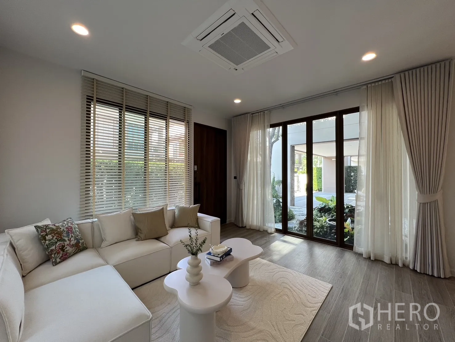 Detached House for rent or sale in Bang Kapi, Bangkok - Lounge facing patio doors and garden with wood-look flooring and white rug.