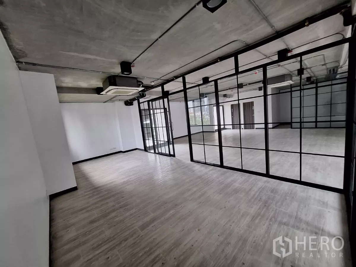 Office Space for rent in Watthana, Bangkok - Private meeting room behind black steel and glass wall within an open-plan office.