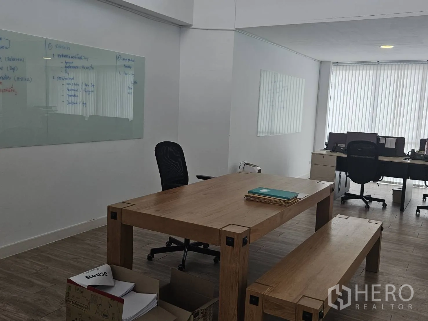 家庭办公室 for rent in Bang Khen, Bangkok - 协作区，木桌与长凳，旁有办公桌与玻璃白板。