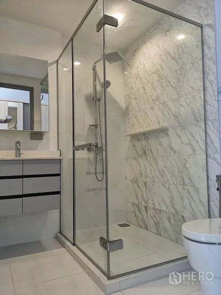 公寓 出租在Watthana, Bangkok - 卫浴配玻璃干湿分离的雨淋花洒与台盆柜。