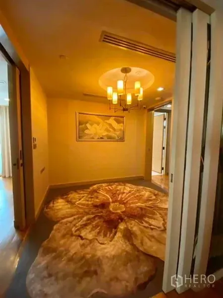 คอนโด ให้เช่าในKhlong Toei, Bangkok - โถงทางเข้าเพดานโคมไฟและพรมลายดอกไม้ขนาดใหญ่ นำไปสู่ห้องนอน