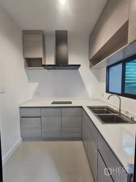 ทาวน์เฮาส์ ให้เช่าในSaphan Sung, Bangkok - ครัวปิดทรงตัวแอล ตู้ลายไม้ เตาไฟฟ้า และหน้าต่างระบายอากาศ