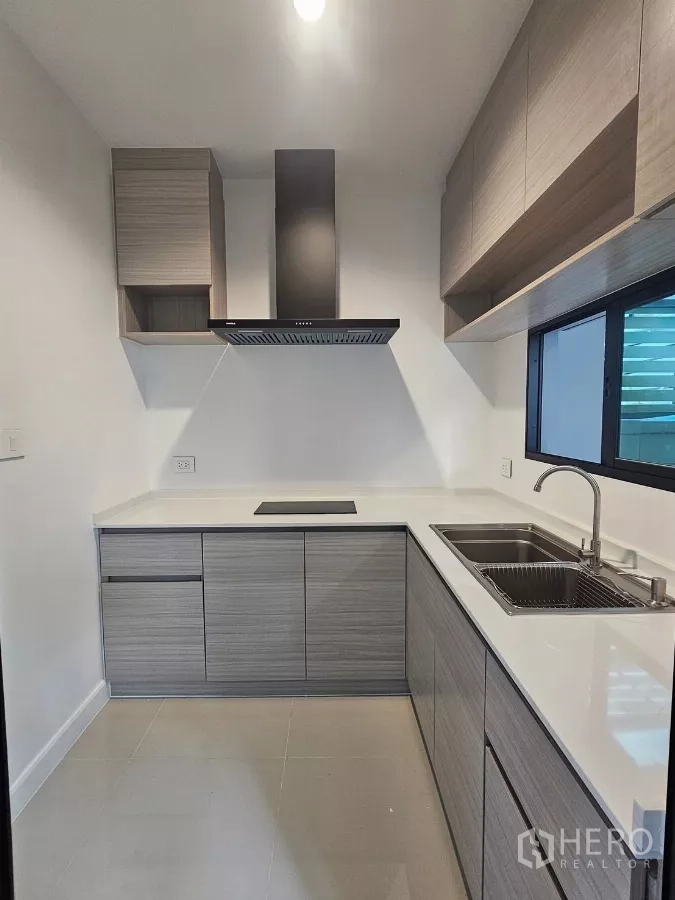 ทาวน์เฮาส์ ให้เช่าในSaphan Sung, Bangkok - ครัวปิดทรงตัวแอล ตู้ลายไม้ เตาไฟฟ้า และหน้าต่างระบายอากาศ