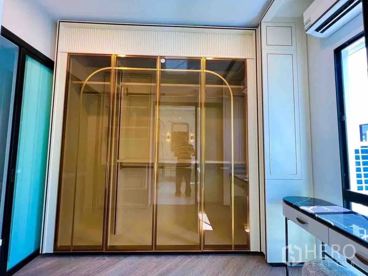 Detached House for rent or sale in Saphan Sung, Bangkok - Gold-framed glass wardrobe doors in custom walk-in closet