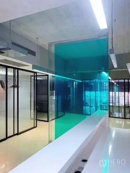 สำนักงาน ให้เช่าในPhaya Thai, Bangkok - ภายในออฟฟิศสมัยใหม่ ผนังกระจกสีฟ้าเขียว ห้องประชุม กรอบกระจกสีดำ พื้นเงา และเพดานลอฟท์ ในพญาไท