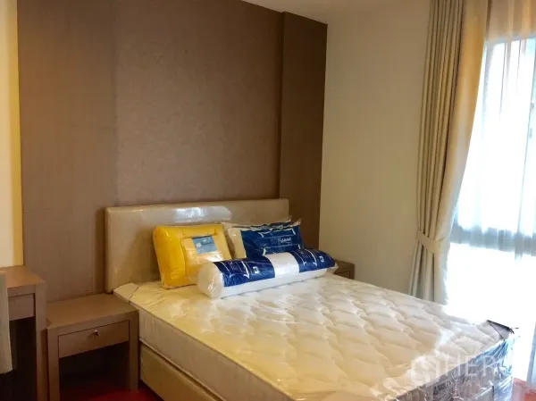 Condominium for rent in Watthana, Bangkok - Cozy bedroom with upholstered headboard, new mattress, bedside tables and soft curtains by the window.