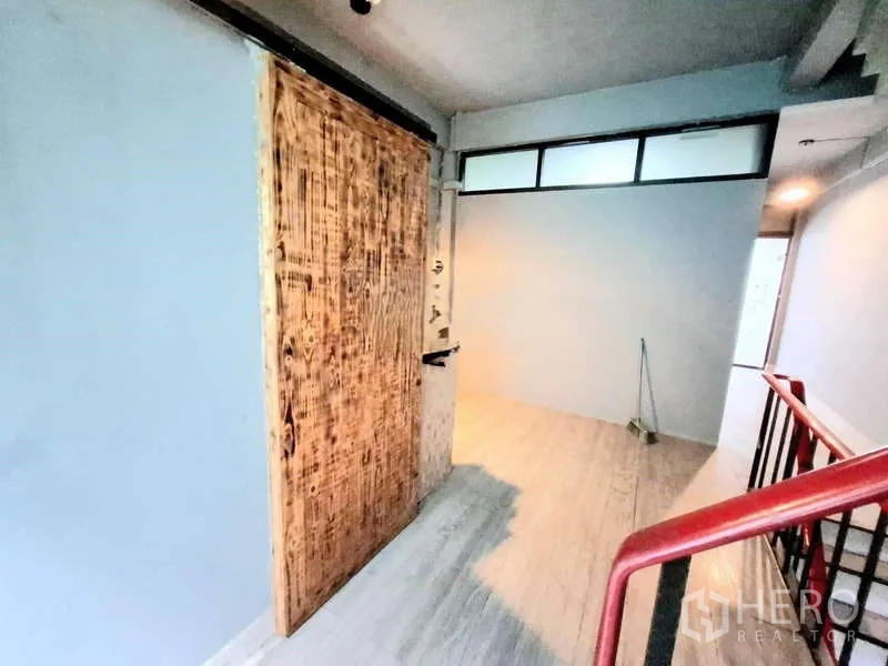 店屋 出租在Bang Rak, Bangkok - 走廊配红色扶手与原木推拉门。