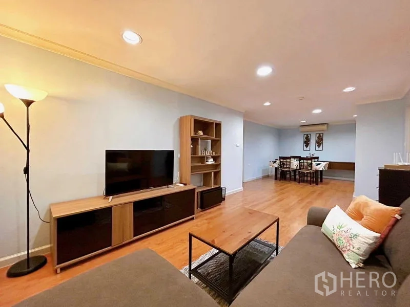 公寓 出租在Watthana, Bangkok - 宽敞客餐厅，电视柜与书架，木地板和嵌入式顶灯。