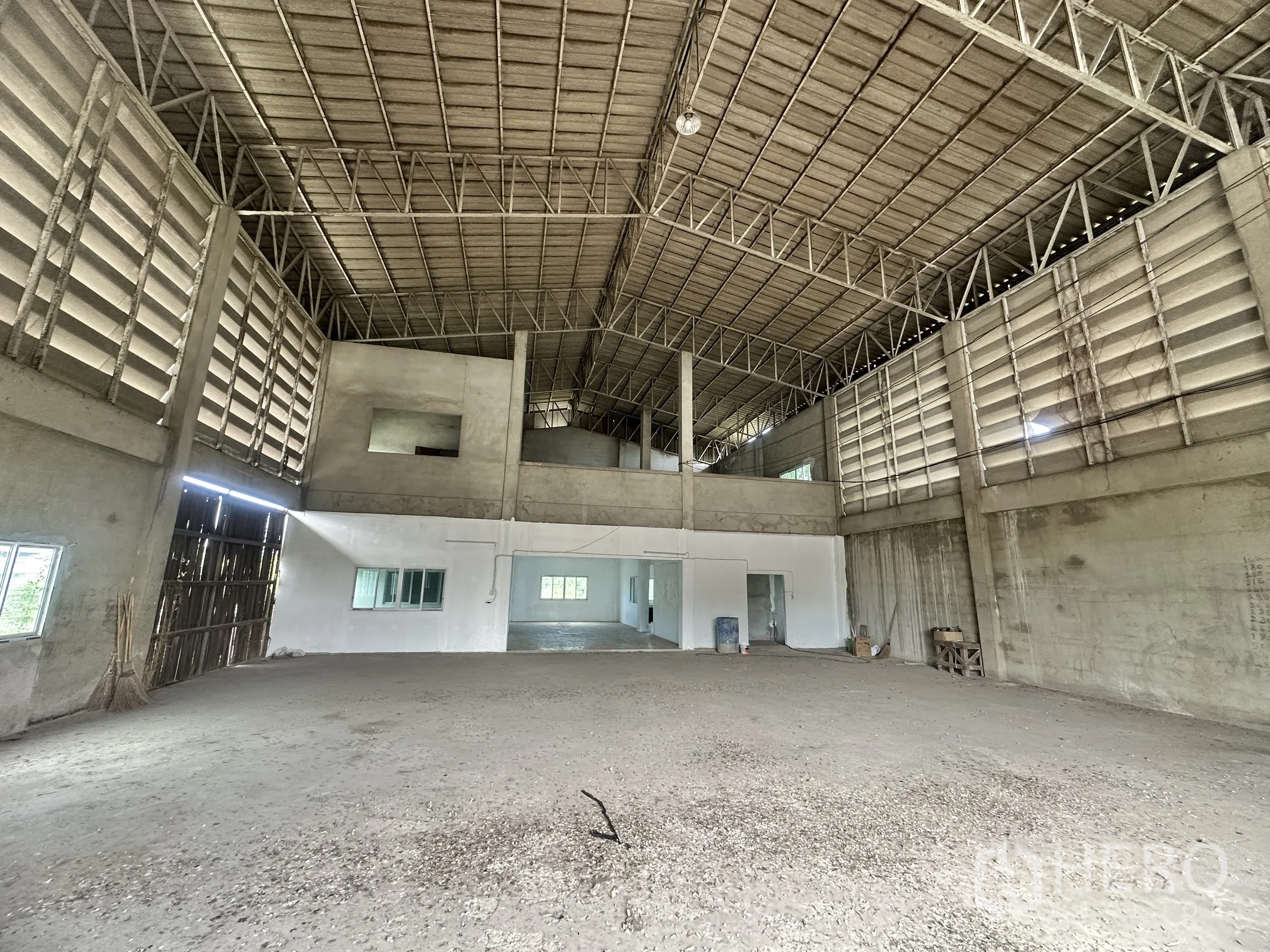 Land for sale in Mueang Samut Prakan, Samut Prakan - Warehouse interior with high steel truss roof, ventilation louvers and mezzanine rooms.
