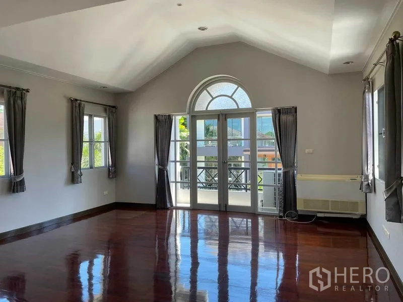 Detached House for sale in Bang Bon, Bangkok - Spacious upstairs room with arched window, balcony doors and polished wooden floors