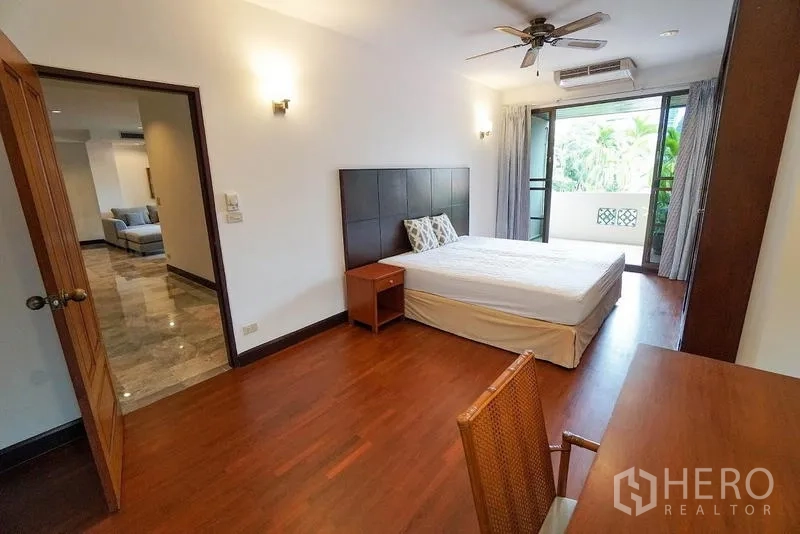 อพาร์ทเมนท์ ให้เช่าในWatthana, Bangkok - ห้องนอนสว่างพร้อมระเบียง พัดลมเพดาน และโต๊ะทำงานมองเห็นต้นไม้