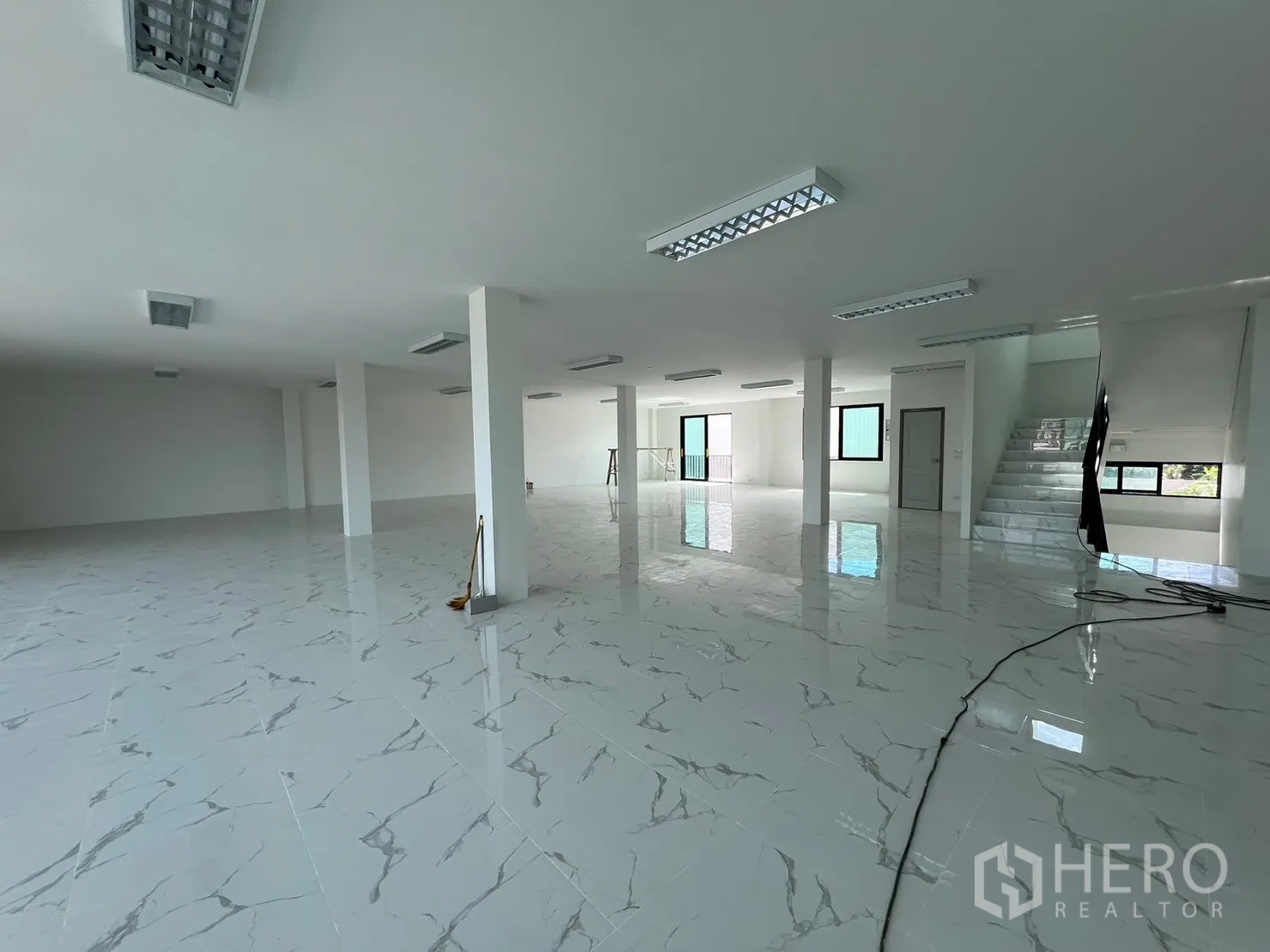 货栈 出租在Samut Prakan - 开放式上层空间，瓷砖地面、承重立柱与嵌入式灯具。