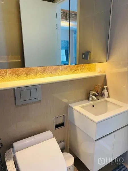 คอนโด ให้เช่าในWatthana, Bangkok - ห้องน้ำเล็กสไตล์โมเดิร์น กระจกมีไฟ ซิงก์ลอย และโถสุขภัณฑ์แบบติดผนังโทนอบอุ่น