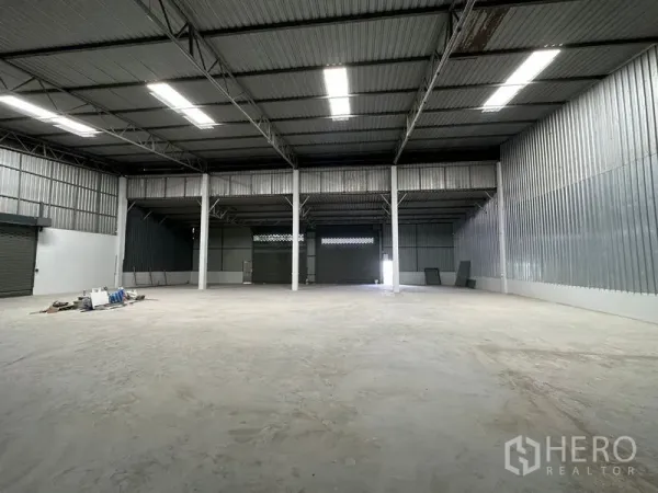 货栈 出租在Khlong Luang, Pathum Thani - 宽敞仓库大厅，设多扇卷闸门、挑高屋顶与采光天窗。