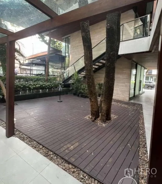 พื้นที่ขายปลีก ให้เช่าในWatthana, Bangkok - เฉลียงมีหลังคากระจก พื้นไม้รอบต้นไม้ และบันไดภายนอก