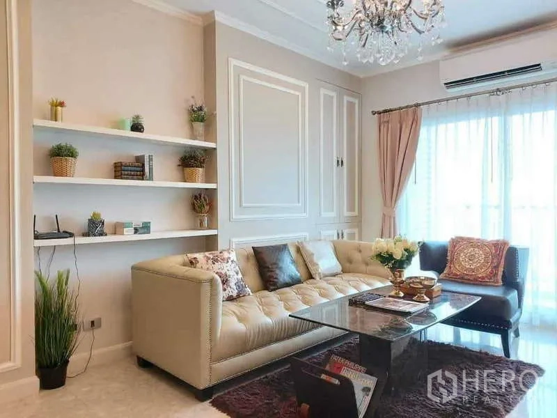 Condominium for rent in Khlong Toei, Bangkok - Bright living room with tufted sofa, chandelier and sheer curtains to the balcony.