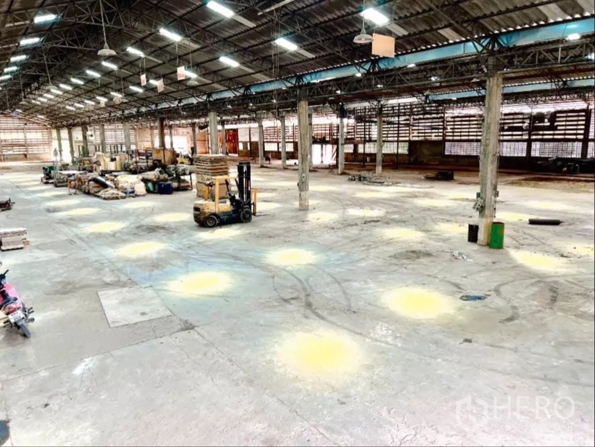 工厂 出租在Sai Noi, Nonthaburi - 开阔仓库地面，叉车与存储区，顶灯照明充足。