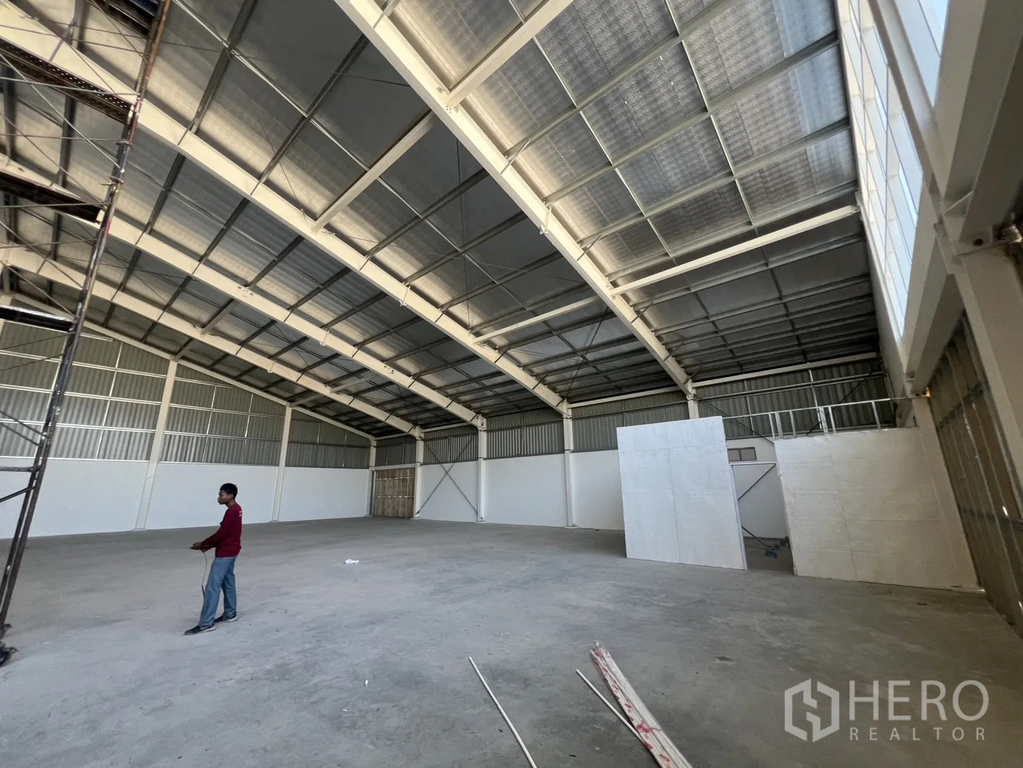 Warehouse for rent in Min Buri, Bangkok - Open-plan warehouse interior with high steel truss roof and smooth concrete floor.