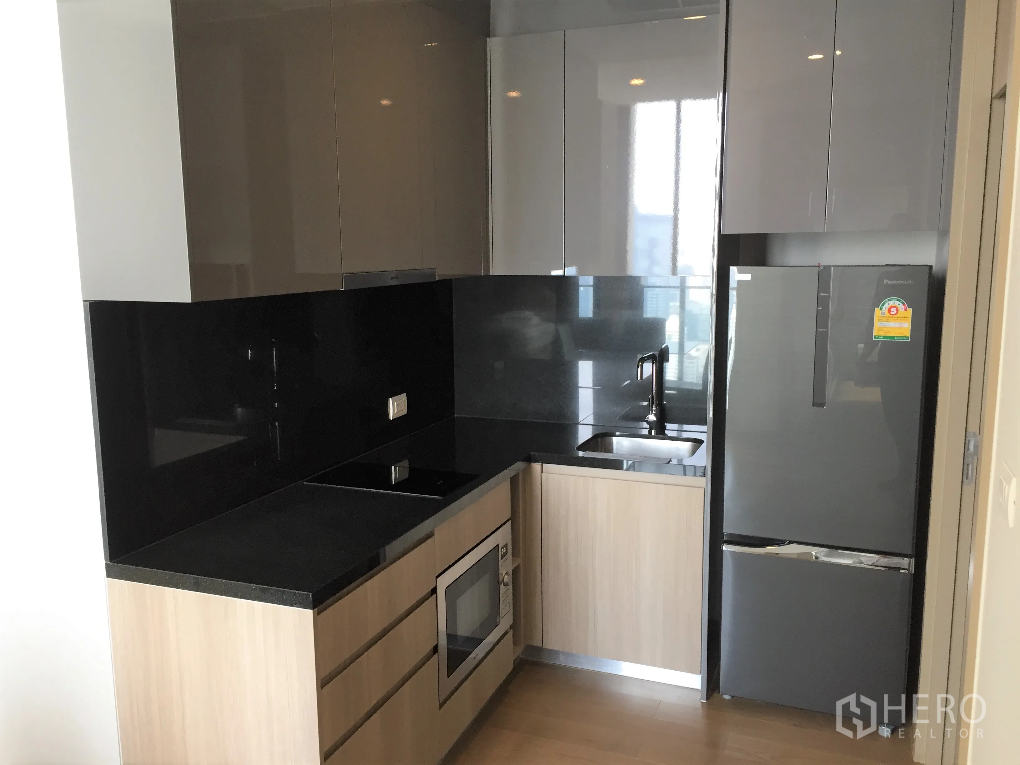 คอนโด ให้เช่าในPathum Wan, Bangkok - ครัวบิวท์อินสมัยใหม่ ตู้ไฮกลอส แผงกันเปื้อนสีดำ และเครื่องใช้ไฟฟ้าครบ