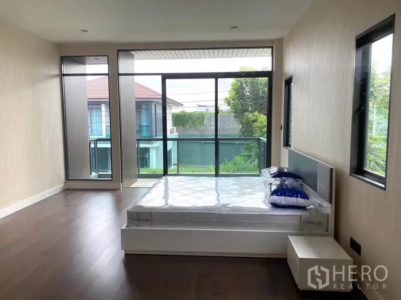 独立式住宅 出租在Saphan Sung, Bangkok - 大卧室，整面落地玻璃墙，面向阳台景观。