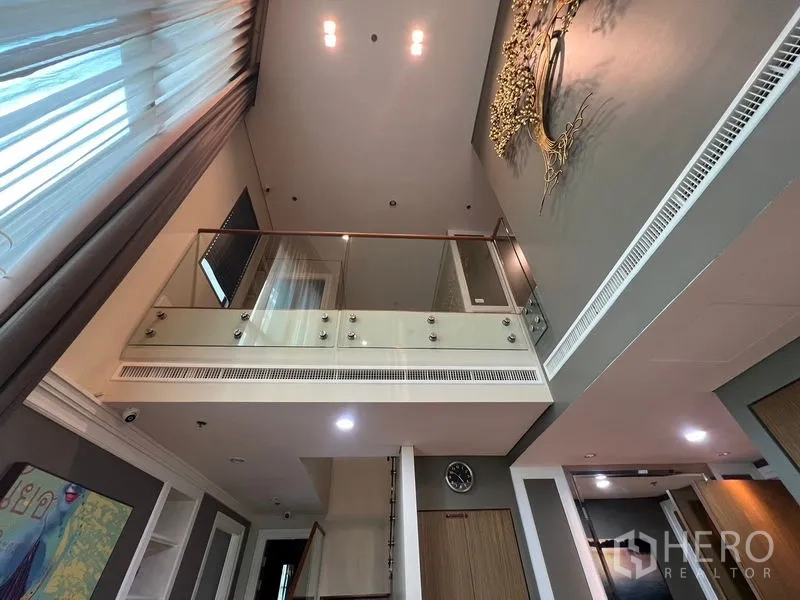 คอนโด ให้เช่าในKhlong Toei, Bangkok - ชั้นลอยราวกระจกมองเห็นโถงนั่งเล่นและงานตกแต่งผนัง